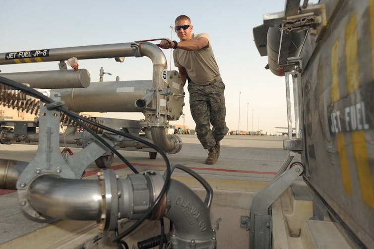 Man stands by jet fuel tank