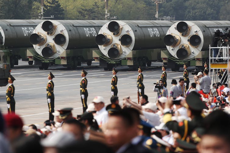 Soldiers parade in front of missiles