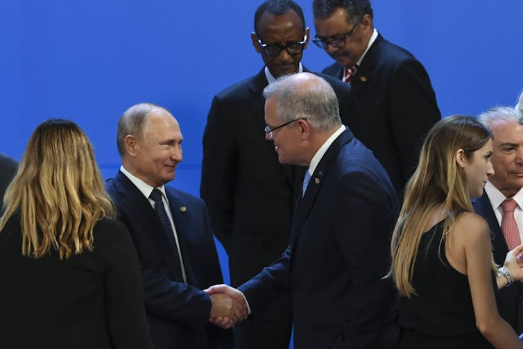 Putin and Morrison shake hands at a previous meeting.