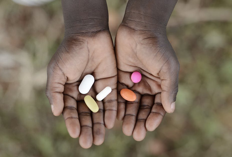 African child holding pills in hands 
