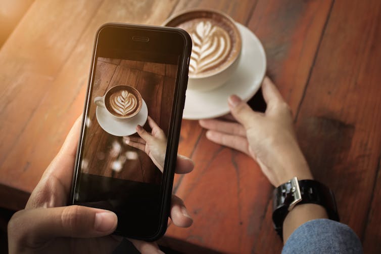 A cafe latte with a phone hovering over it