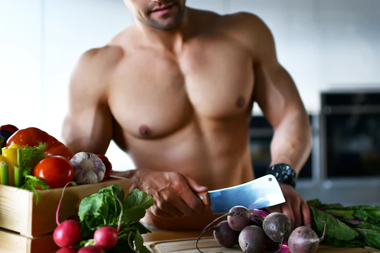 topless man cuts vegetables