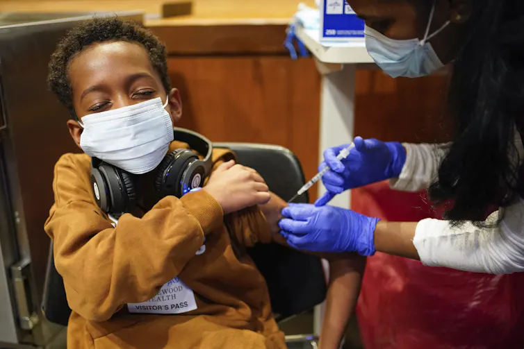 enfant qui reçoit un vaccin contre la Covid-19 aux États-Unis