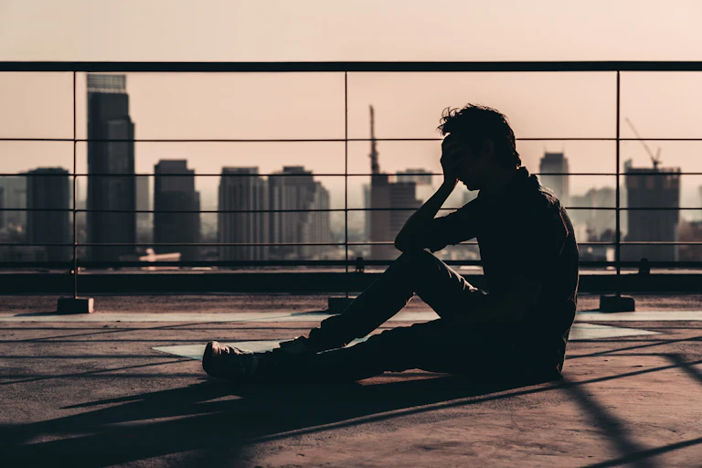 Man sitting on rooftop head in hands