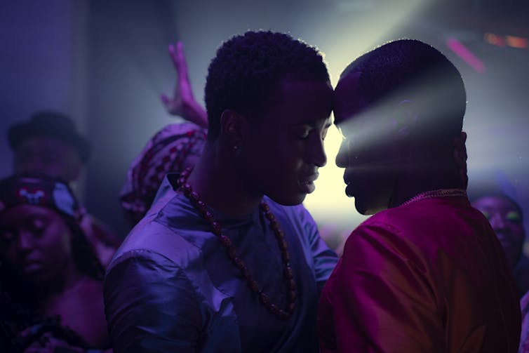 Production image, two black men lean in to kiss