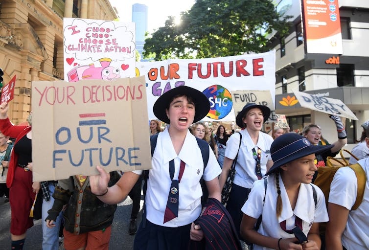 School students march about climate change, holding banners, chanting