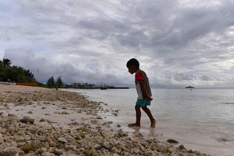 A child walks on a beach in Tuvalu