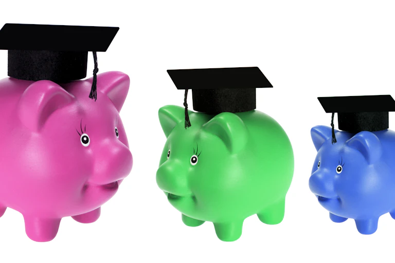Three different-coloured piggybanks with mortar boards on top