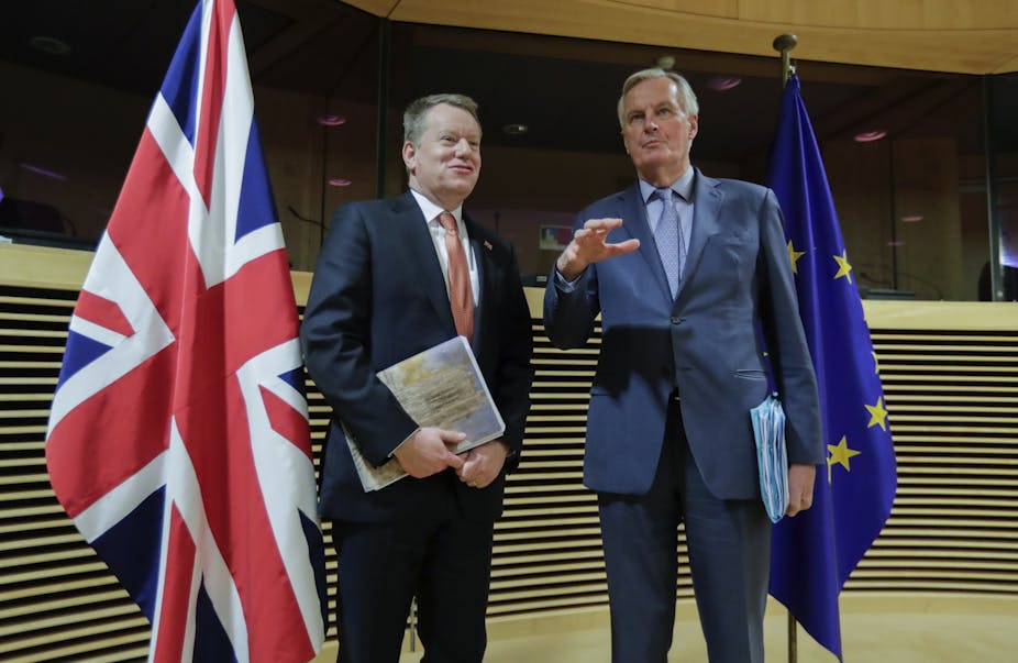David Frost and Michel Barnier standing side by side and flanked by a UK and an EU flag.