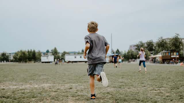 A young boy runs on a playing field