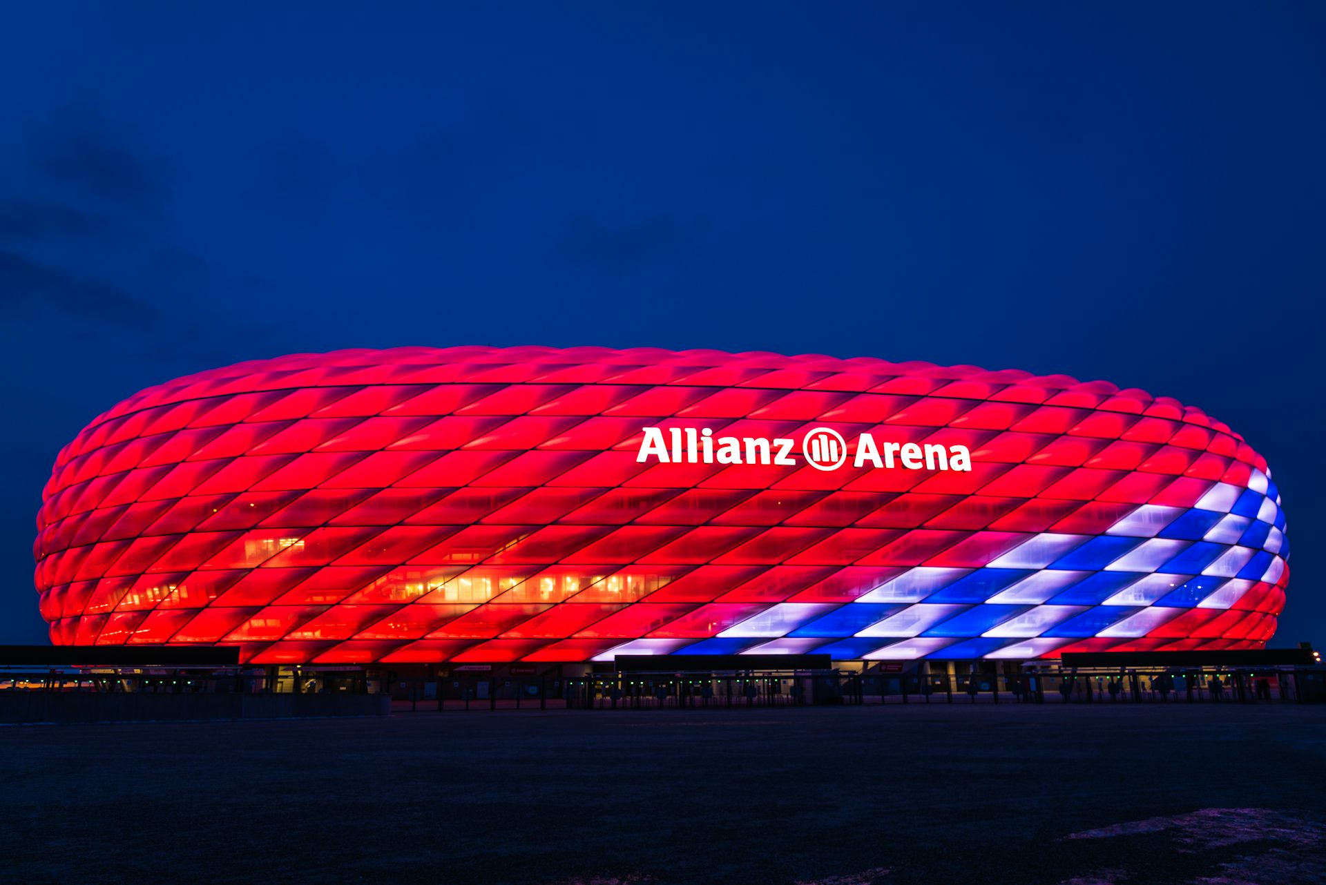 An image of Bayern Munich's Allianz stadium lit up in red at night.