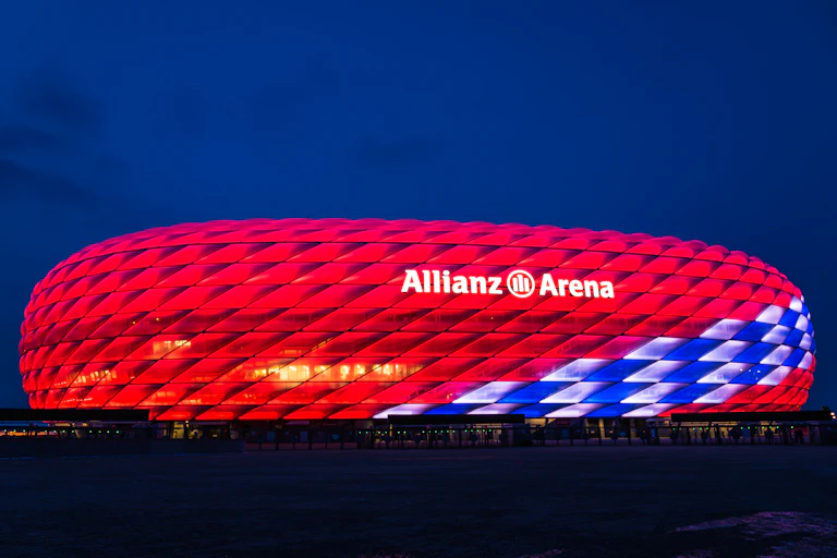 An image of Bayern Munich's Allianz stadium lit up in red at night.