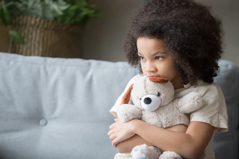 Sad girl hugs teddy