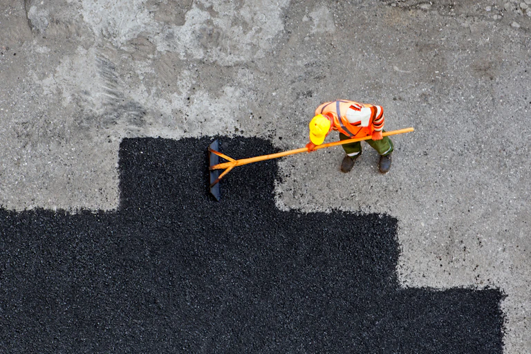 Aerial view of worker repairing road surface.
