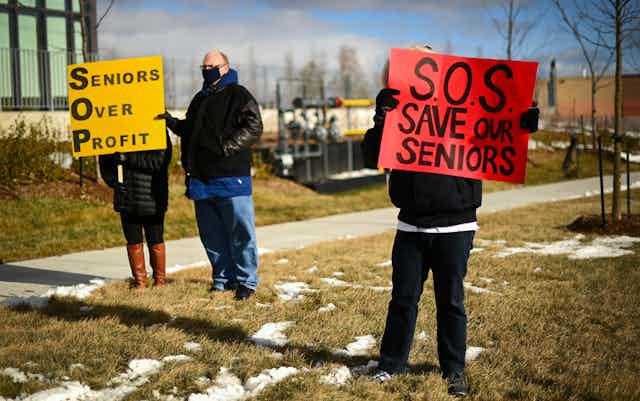 People protest outside a long-term care home, one carrying a sign that reads Save our Seniors and another carrying a sign that reads Seniors Over Profit