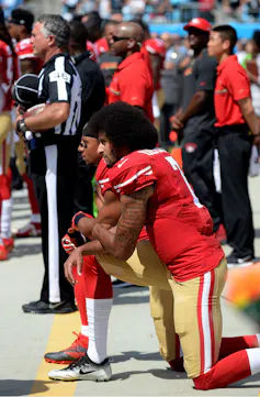 Colin Kaepernick kneels during the US national anthem in a sign of protest.