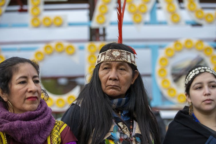 Three people in front of a sign