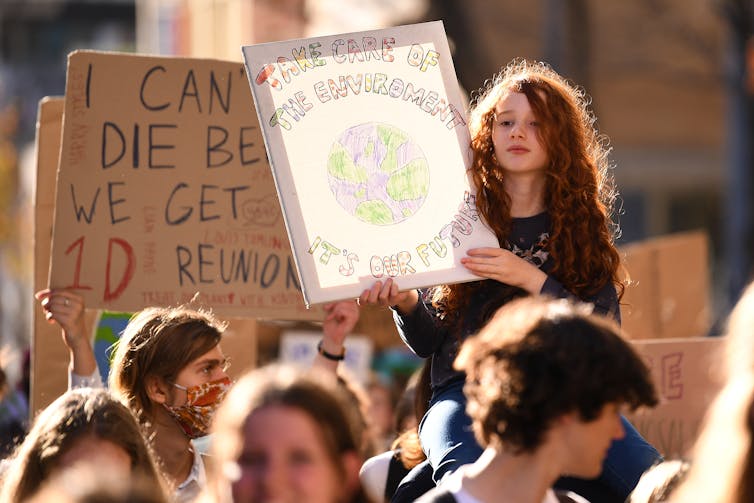 A young student holds a sign at a climate protest