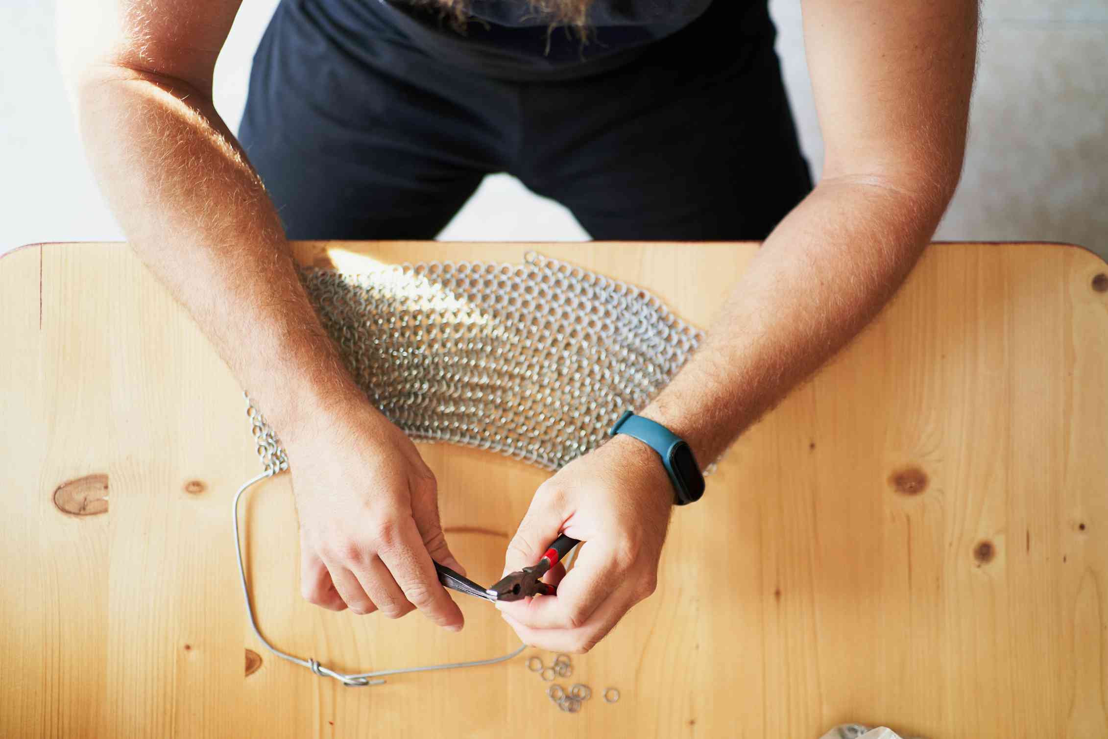 A man uses pliers.
