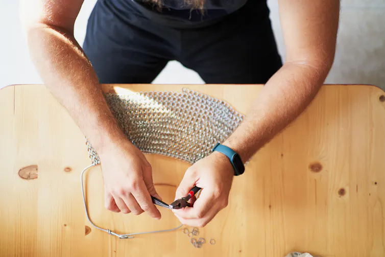 A man uses pliers.