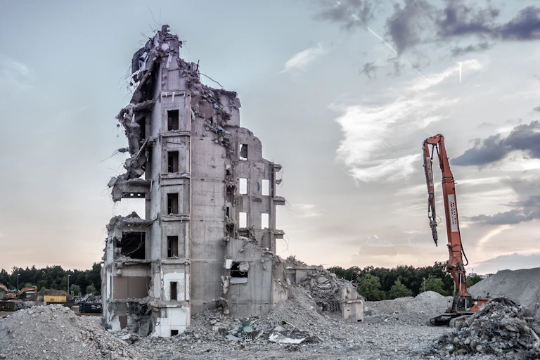 A partly demolished building and crane
