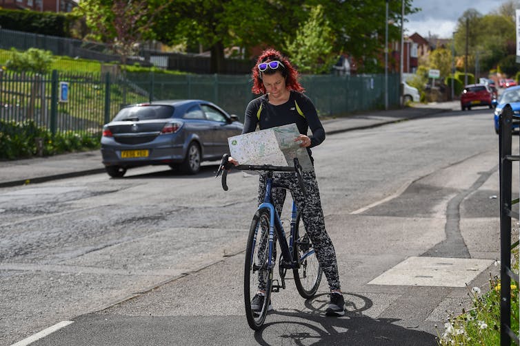 A person on a bike reads a map