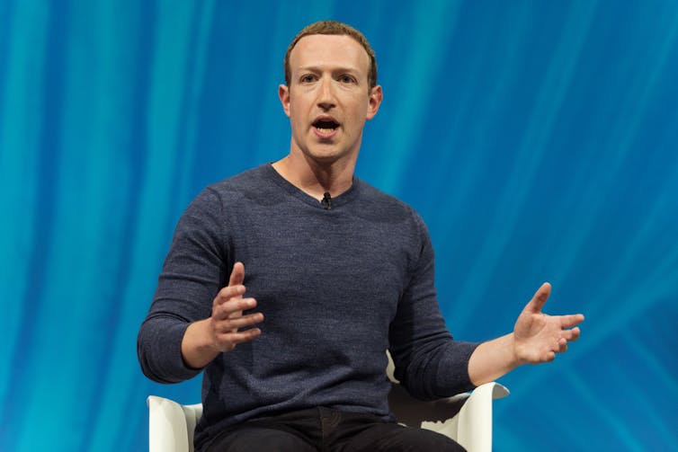 Mark Zuckerberg giving a speech against a blue background.