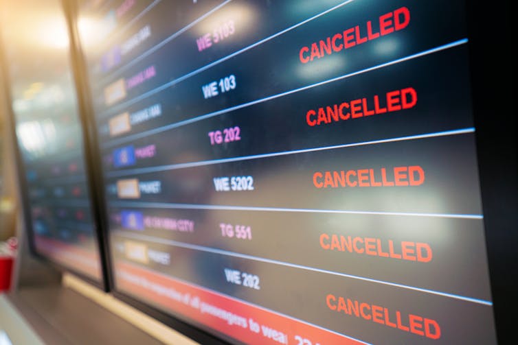 A flight status display at an airport shows 