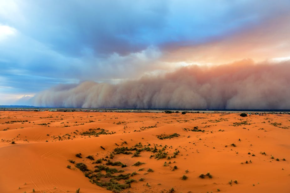 Sandstorm meeting clouds, sky and desert.
