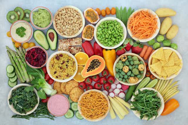 An assortment of plant-based foods, including avocados, kiwis, carrots, edamame and beans.