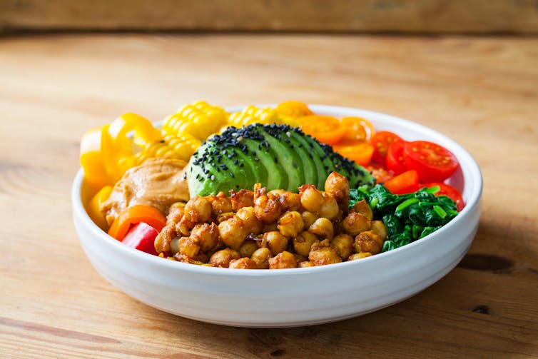 A vegan 'Buddha' bowl meal, with chickpeas, avocado, tomatoes and corn.