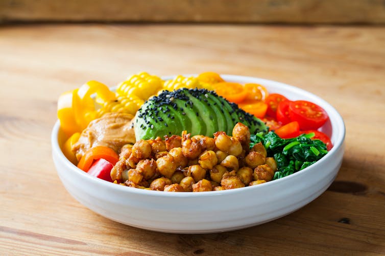 Una comida vegana de tazón de 'Buda', con garbanzos, aguacate, tomates y maíz.