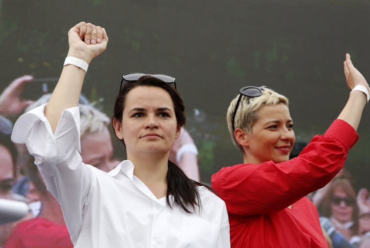 Belarusian opposition presidential candidate Svetlana Tikhanovskaya (L) raises her fist next to Maria Kolesnikova (R).
