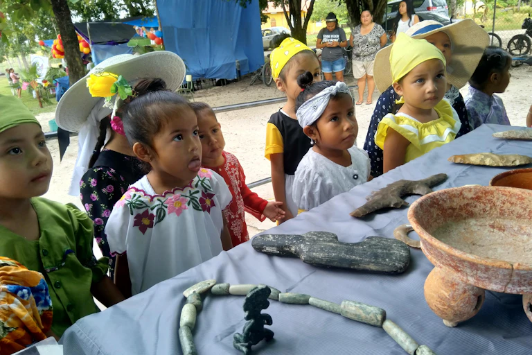 Local kids look at ancient belongings.