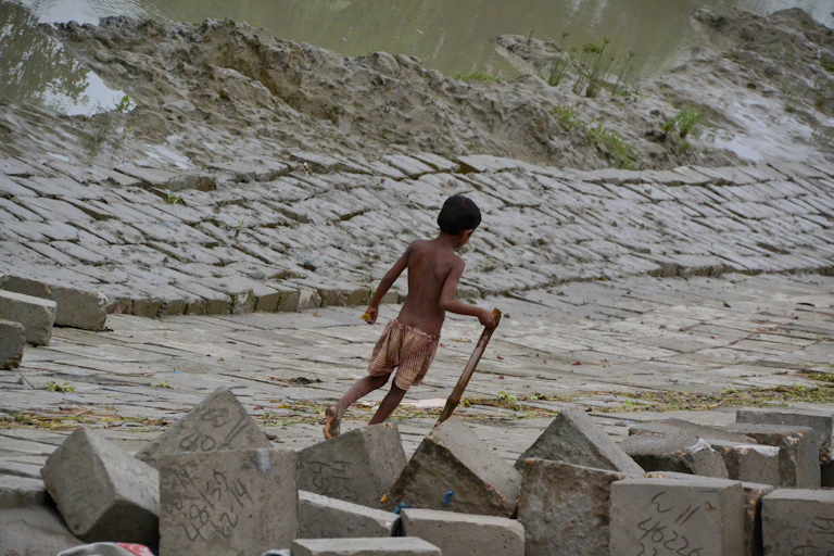 A boy walks by a river