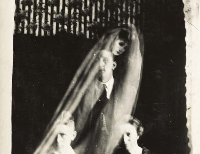 Une image semi-translucide d'une femme voilée vue derrière un homme.