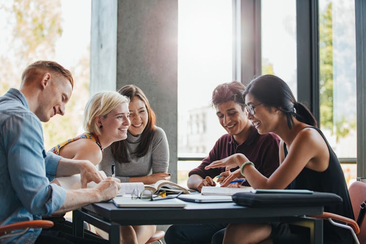 Group of university students enjoying a discussion around a table