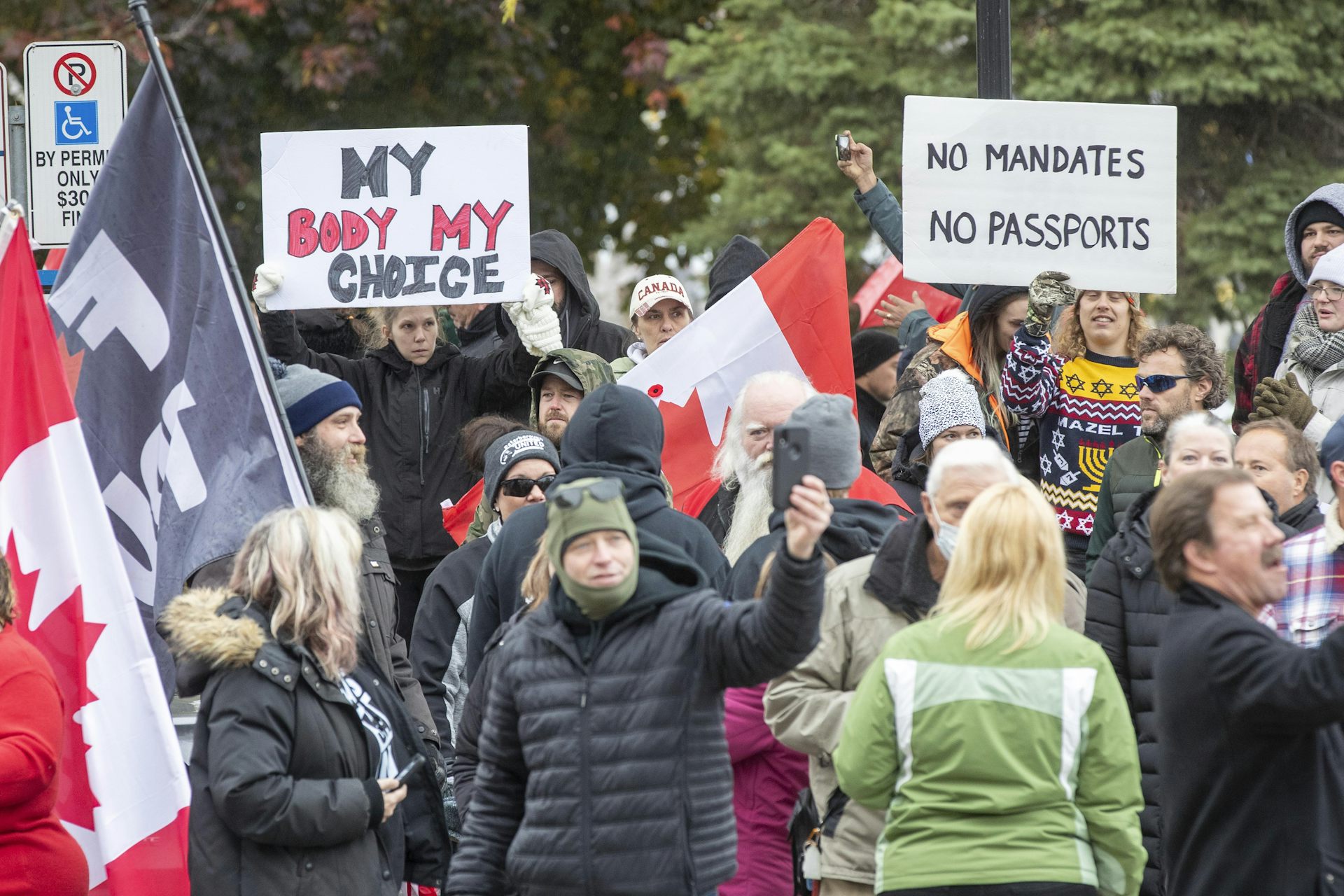 Protesters carry signs that read My Body My Choice and No Mandates No Passports.