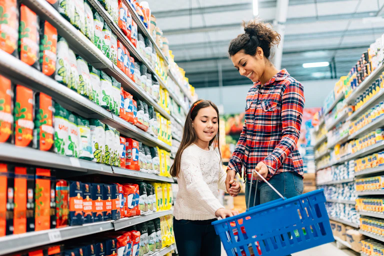 A woman and her daughter in a drink aisle of a supermarket.