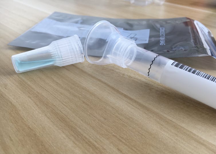 A DNA test kit and spit tube is on a table.