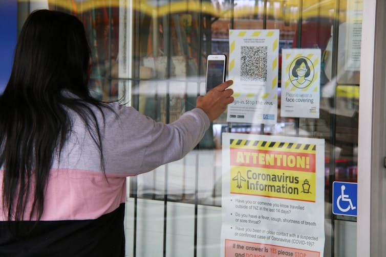 Woman scanning QR code on shop window