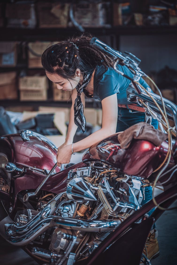 Woman repairing a motorbike