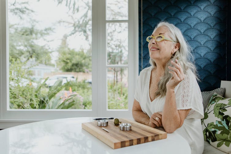 An older woman smokes a joint and smiles