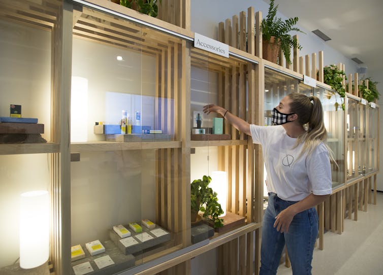 An employee arranges a variety of products at a cannabis store.