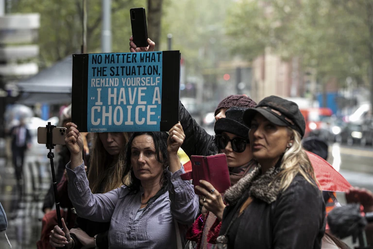 Protesters holding anti-vaccination placard at rally