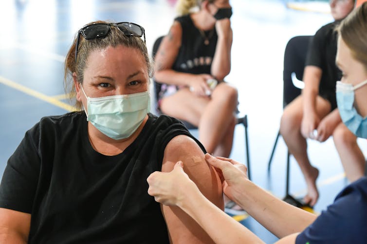 Person getting bandaid on upper arm after COVID vaccine