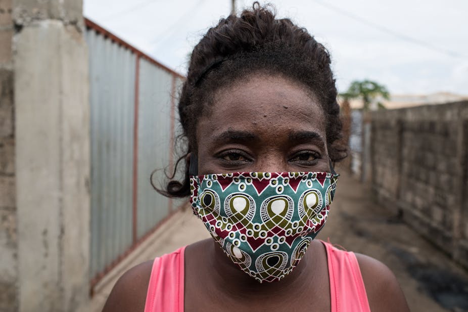 A woman wears a COVID-19 mask on an alley in a poor neighbourhood in Maputo, Mozambique