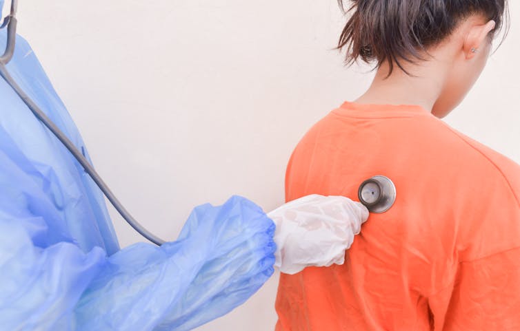 Doctor listens to a child's back with a stethoscope.