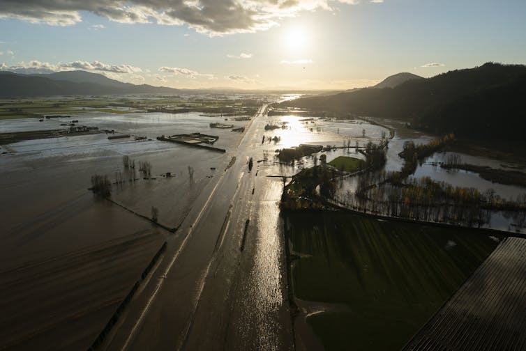 Aerial view of a flooded highway, homes and farmland