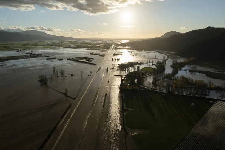 Aerial view of a flooded highway, homes and farmland